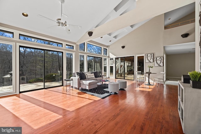 living room with a ceiling fan, wood finished floors, baseboards, high vaulted ceiling, and recessed lighting