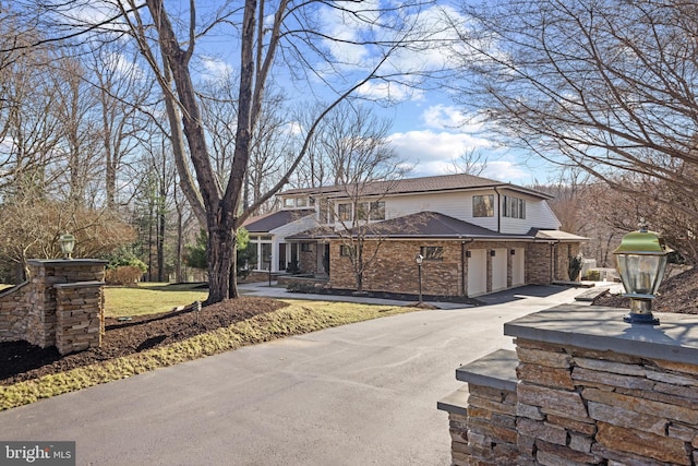 view of front facade featuring a garage, brick siding, and driveway