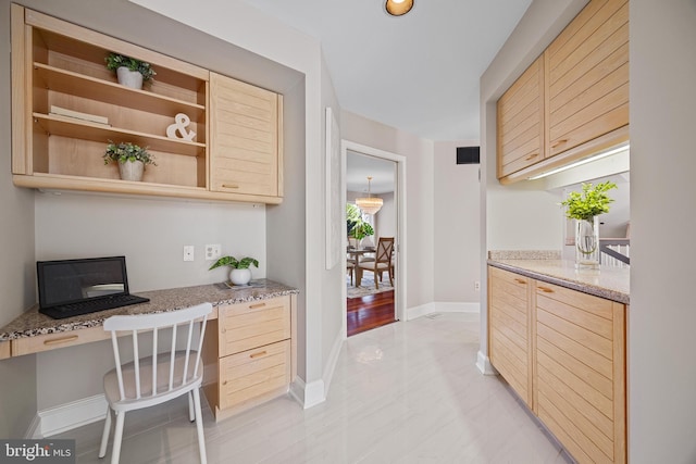 office area with baseboards, visible vents, and built in study area