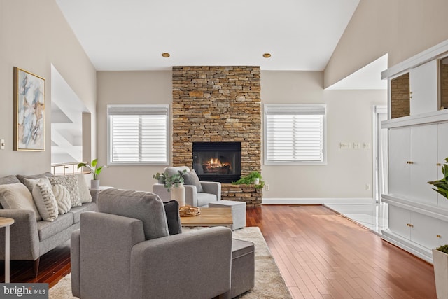 living room featuring lofted ceiling, hardwood / wood-style flooring, a fireplace, and a wealth of natural light