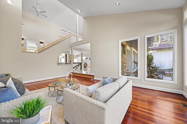 living area featuring baseboards, wood finished floors, and stairs