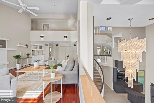 living room with stairway, plenty of natural light, a high ceiling, and wood finished floors