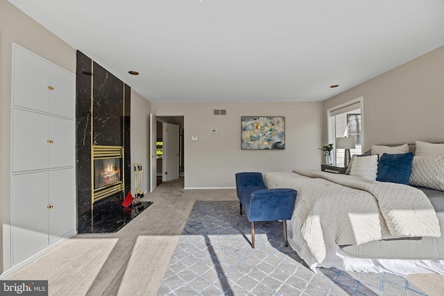 bedroom featuring light carpet, visible vents, a fireplace, and baseboards