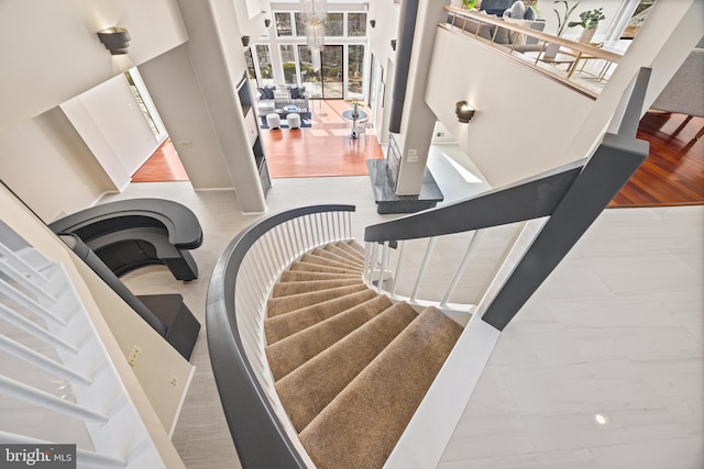 stairway with a chandelier and marble finish floor