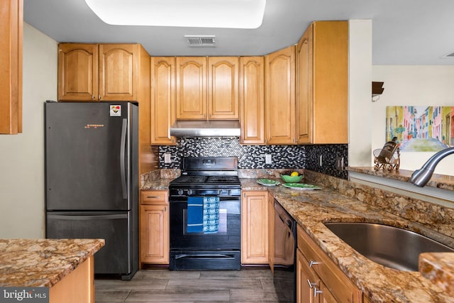 kitchen with visible vents, under cabinet range hood, decorative backsplash, black appliances, and a sink