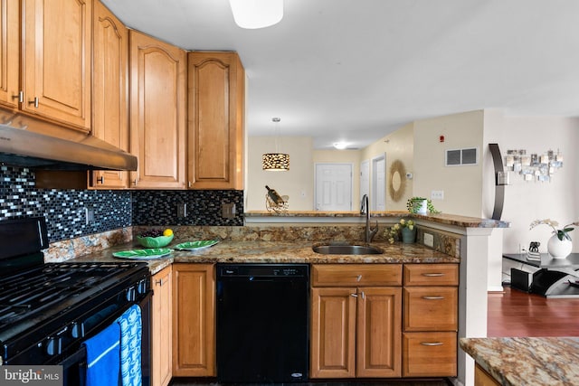 kitchen featuring visible vents, a peninsula, a sink, black appliances, and under cabinet range hood