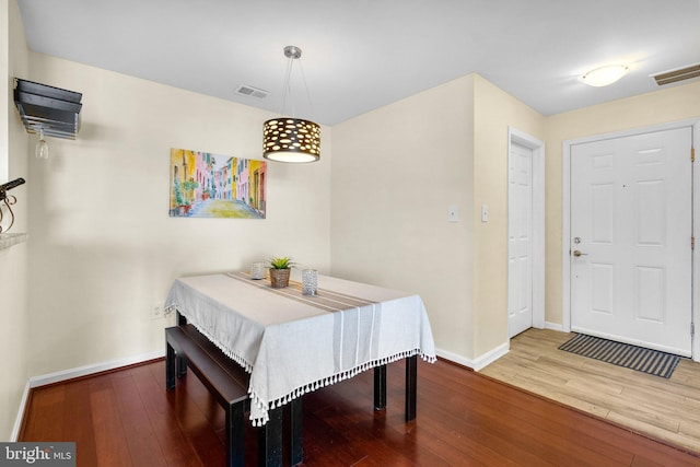 dining space with visible vents, wood-type flooring, and baseboards