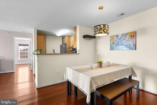 dining space with visible vents, dark wood-type flooring, and baseboards