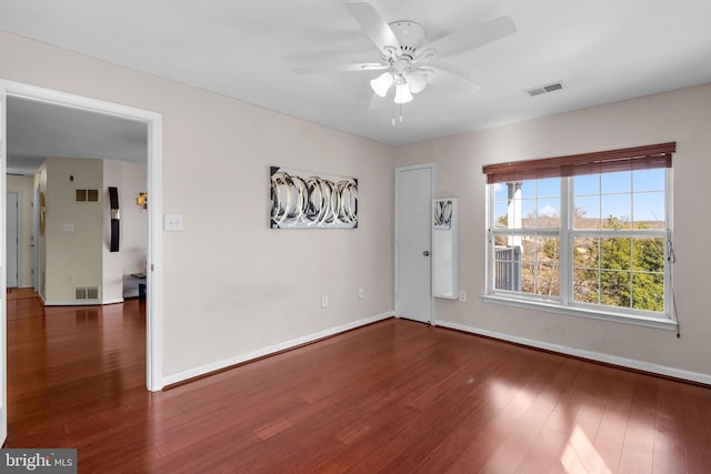 unfurnished room with visible vents, baseboards, wood finished floors, and a ceiling fan