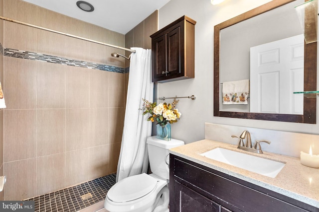 full bath featuring a tile shower, toilet, and vanity