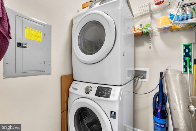 laundry area with electric panel, laundry area, and stacked washing maching and dryer