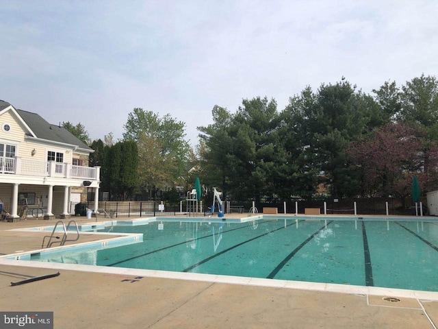 community pool featuring a patio and fence