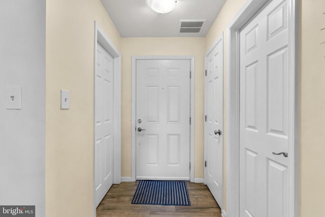 doorway to outside featuring wood finished floors, visible vents, and baseboards