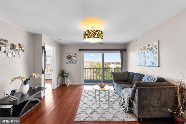 living area with baseboards and wood finished floors