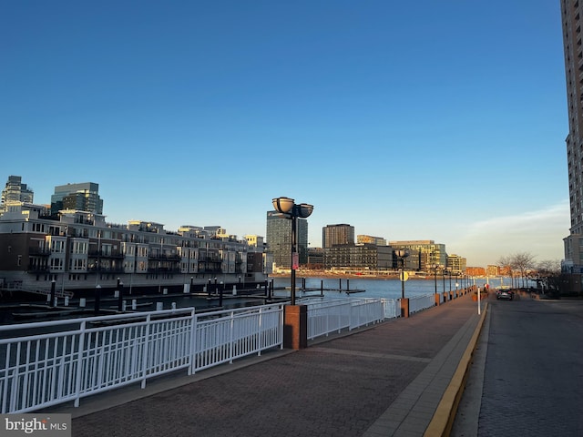 view of street featuring sidewalks, a water view, and a city view