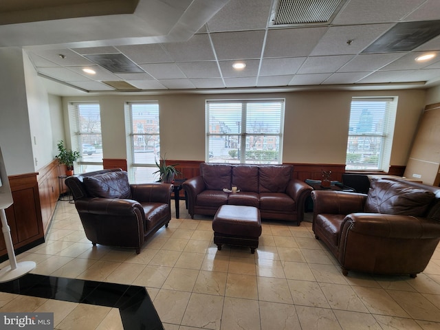 living room with visible vents, a wainscoted wall, light tile patterned flooring, recessed lighting, and a drop ceiling