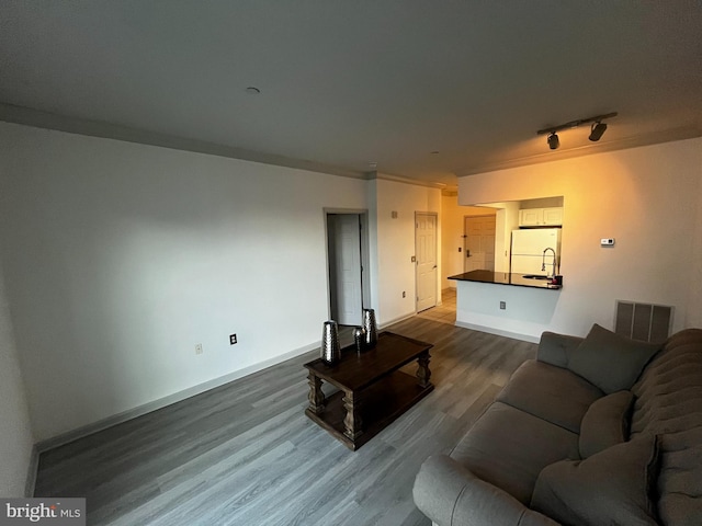 living area featuring track lighting, baseboards, visible vents, and dark wood-style flooring