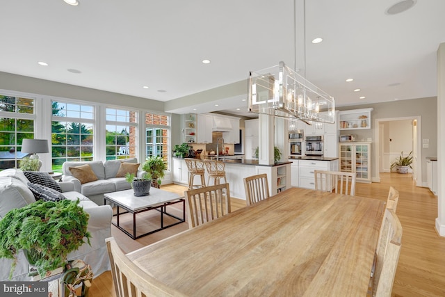 dining space with recessed lighting and light wood-type flooring