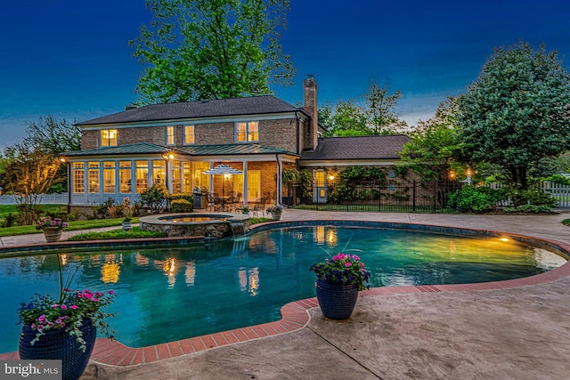view of swimming pool featuring fence, a sunroom, a pool with connected hot tub, and a patio area