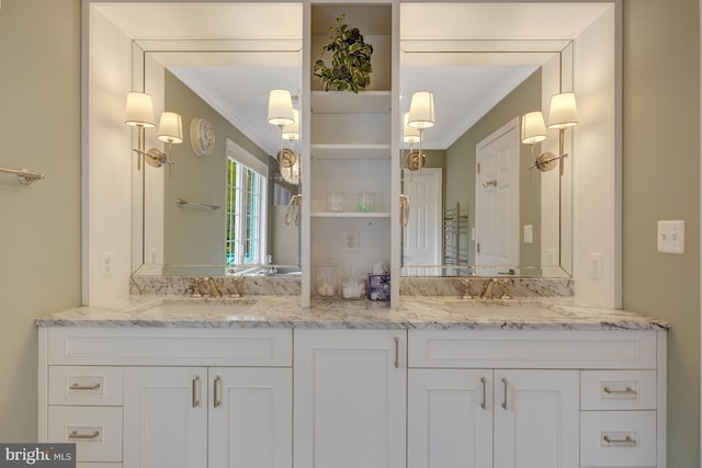 full bath with a sink, crown molding, and double vanity