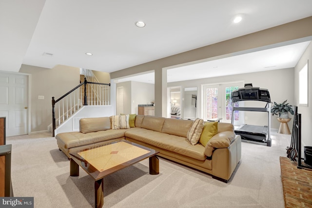 living area featuring recessed lighting, light carpet, french doors, and stairway