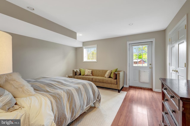 bedroom featuring light wood-type flooring, recessed lighting, baseboards, and multiple windows
