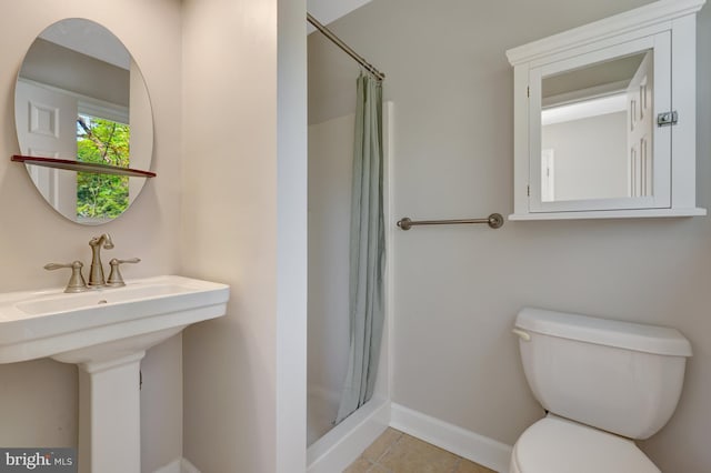 full bath with baseboards, tile patterned floors, toilet, and a shower stall