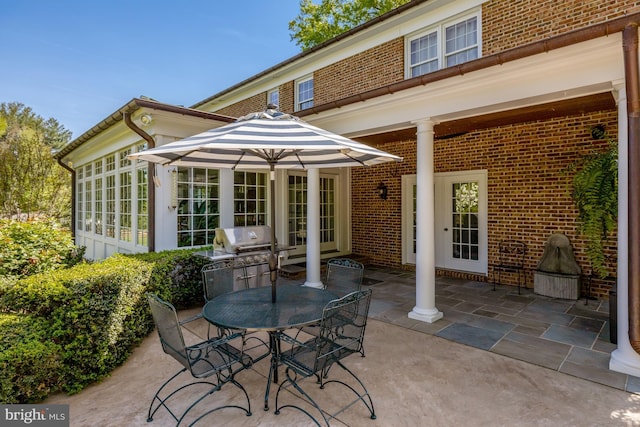 view of patio with outdoor dining area, grilling area, and a sunroom