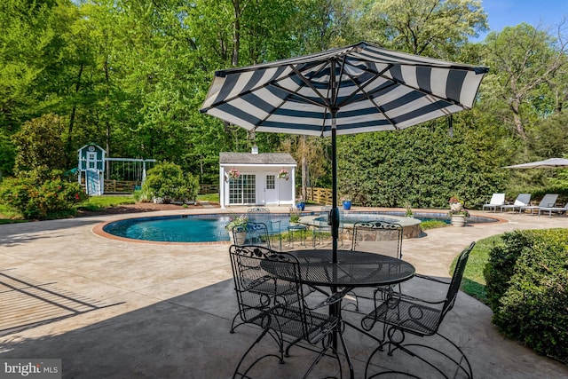 pool featuring an outbuilding and a patio area