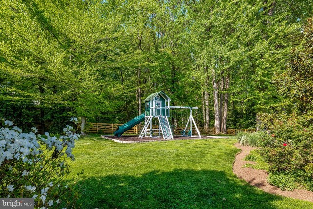 view of jungle gym featuring fence and a yard