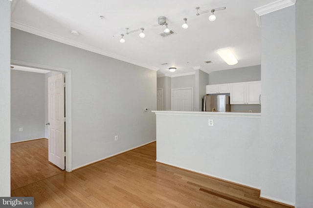 spare room with visible vents, light wood-style flooring, and crown molding