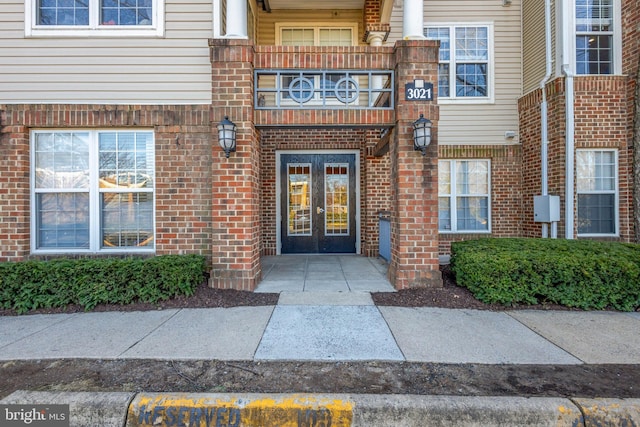 doorway to property featuring french doors and brick siding