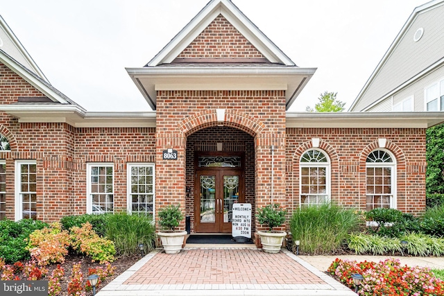 entrance to property featuring french doors and brick siding