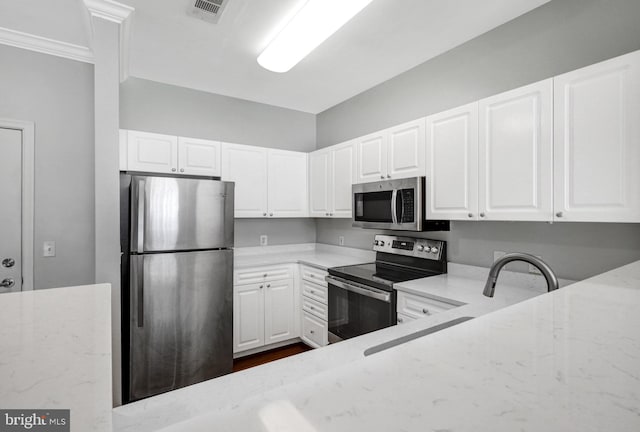 kitchen with visible vents, white cabinets, appliances with stainless steel finishes, and light stone countertops