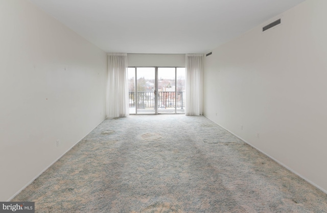 unfurnished room with carpet flooring and visible vents