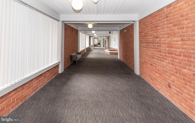 hallway with brick wall and carpet floors