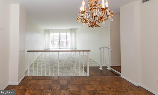 empty room with visible vents, baseboards, and a notable chandelier