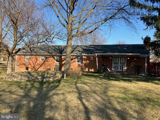 view of front of house with a front lawn and a chimney