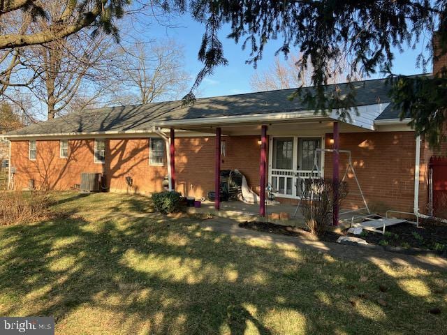 back of house with a patio, central air condition unit, and a yard