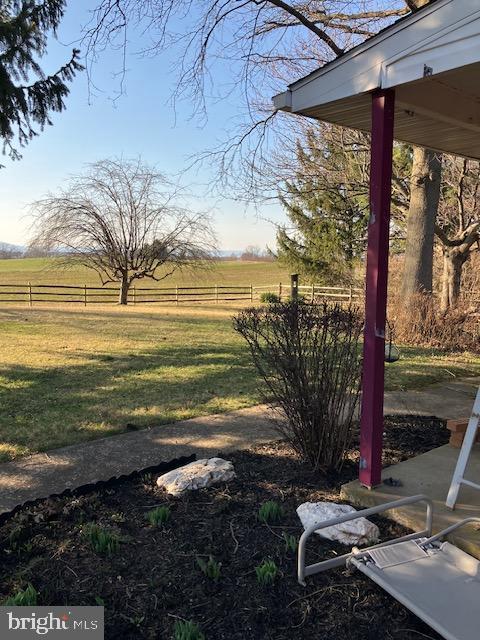 view of yard featuring a rural view and fence