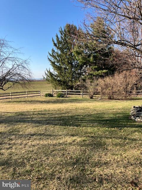 view of yard with a rural view and fence