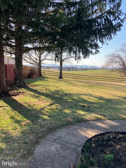 view of yard with a rural view and fence