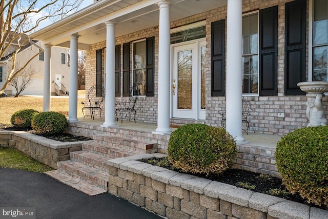 entrance to property with brick siding and covered porch