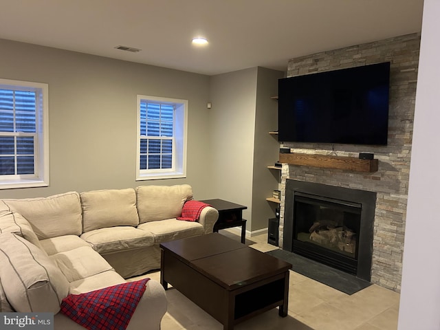 living room with recessed lighting, visible vents, light tile patterned flooring, and a fireplace