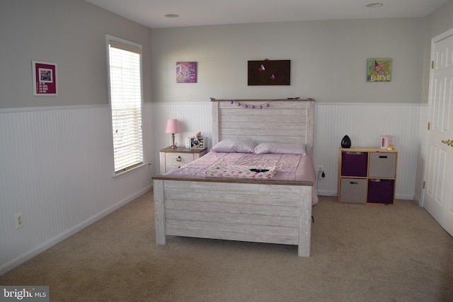 carpeted bedroom featuring wainscoting