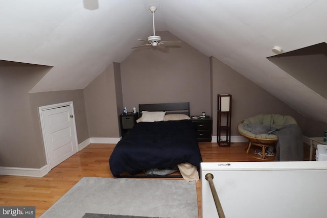 bedroom with ceiling fan, baseboards, lofted ceiling, and wood finished floors