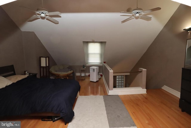 bedroom with baseboards, a ceiling fan, lofted ceiling, and wood finished floors