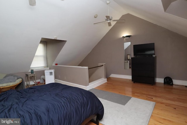 bedroom with ceiling fan, baseboards, wood finished floors, and vaulted ceiling