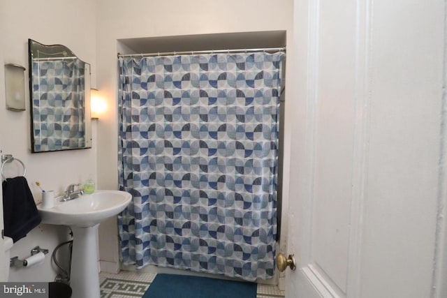 full bath featuring a sink and curtained shower