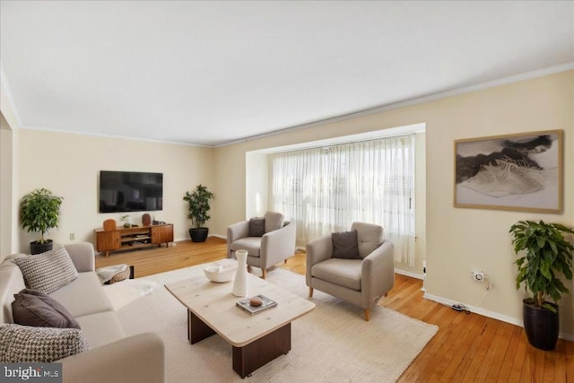 living room with baseboards, ornamental molding, and hardwood / wood-style flooring